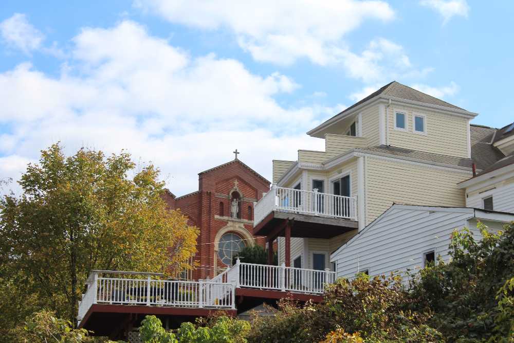 Photo of a South Side Slopes home with a large deck and the St. Paul Monastery in the background by Jackie Bender, 2021
