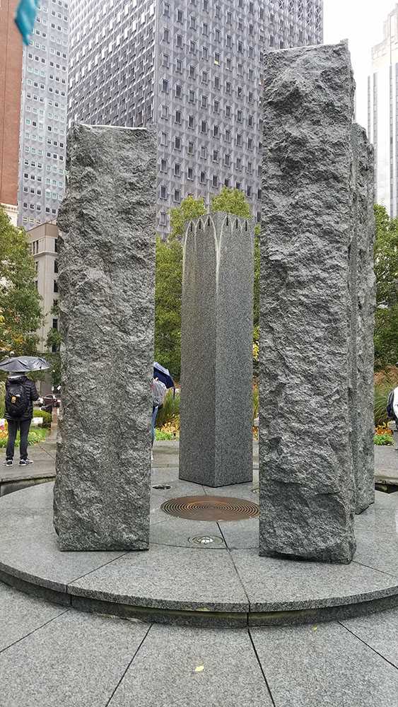 Fountain at the center of Mellon Green consisting of five, tall stone pillars. Photo by Elizabeth Madison. 