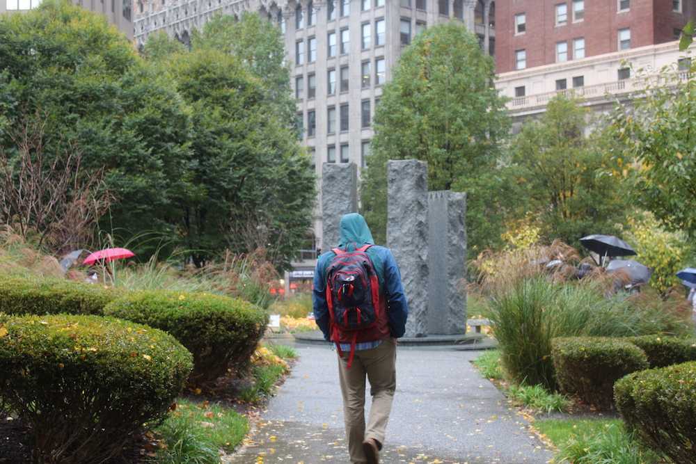 Student walks toward the fountain in Mellon Green. Photo by Elizabeth Madison